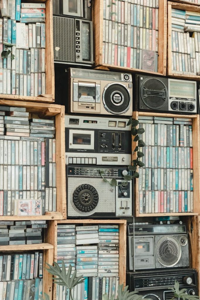A vertical display of retro audio equipment and cassette tapes in wooden shelves, perfect for a nostalgic theme.